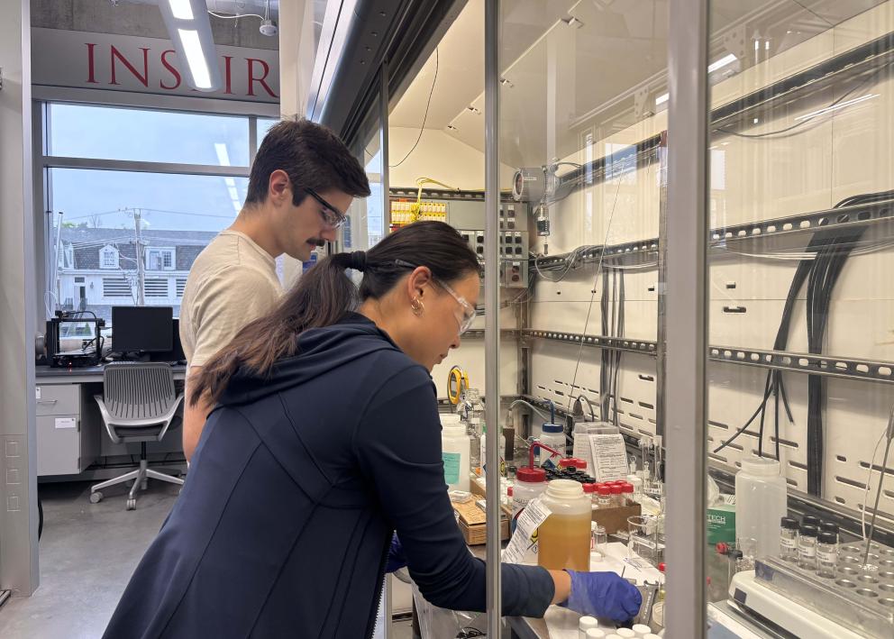 Two people taking notes on the chemicals in a display case